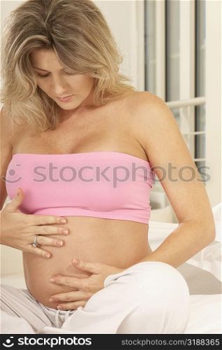 Close-up of a pregnant woman touching her abdomen