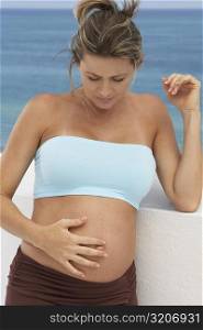 Close-up of a pregnant woman touching her abdomen