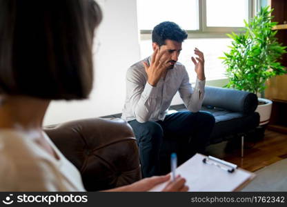 Close-up of a psychologist taking notes on clipboard during therapy session with her worried patient. Psychology and mental health concept.
