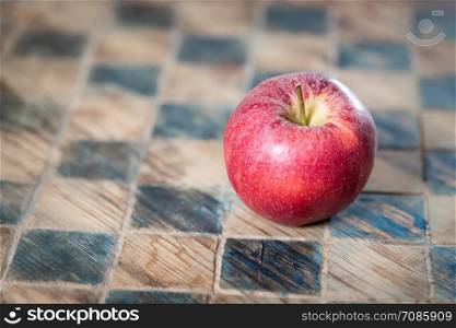 Close up of a red apple on a checked board