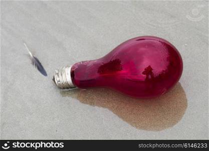 Close-up of a red light bulb on sand, Pacific Rim National Park Reserve, British Columbia, Canada