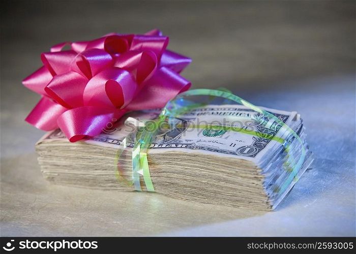 Close-up of a ribbon flower on a bundle of one dollar bills
