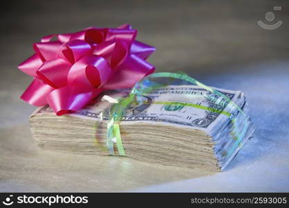 Close-up of a ribbon flower on a bundle of one dollar bills
