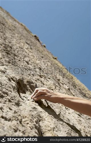 Close-up of a rock climber&acute;s hand gripping on a rock