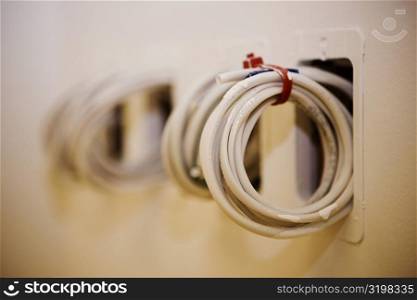 Close-up of a roll of cables coming out from a wall