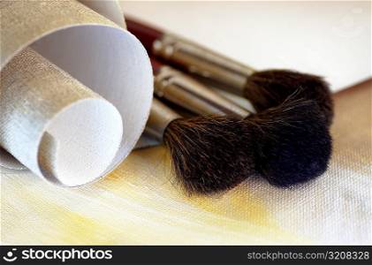 Close-up of a roll of canvas and paintbrushes