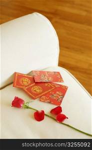 Close-up of a rose and envelopes on a couch