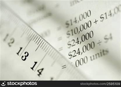 Close-up of a ruler with a financial document