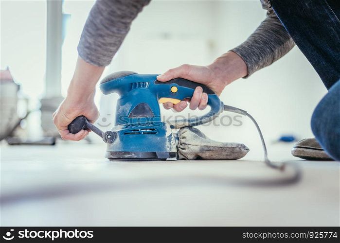 Close up of a sander power tool for DIY on wooden parquet floor