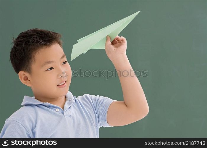 Close-up of a schoolboy playing with a paper airplane