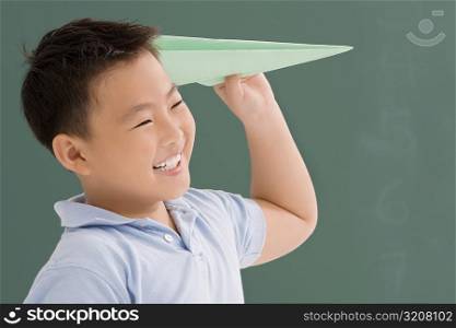 Close-up of a schoolboy playing with a paper airplane