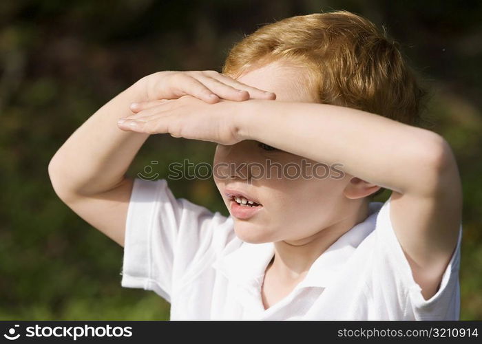 Close-up of a schoolboy shielding his eyes