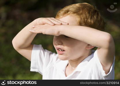 Close-up of a schoolboy shielding his eyes