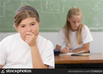 Close-up of a schoolgirl thinking in a classroom