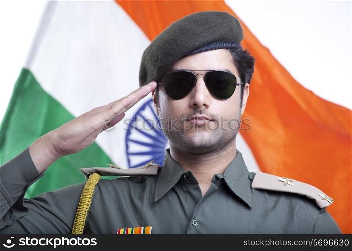 Close-up of a security guard saluting with Indian flag in the background