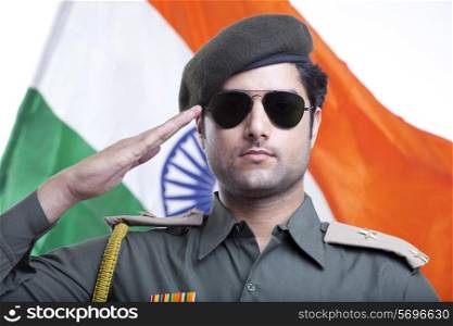 Close-up of a security guard saluting with Indian flag in the background