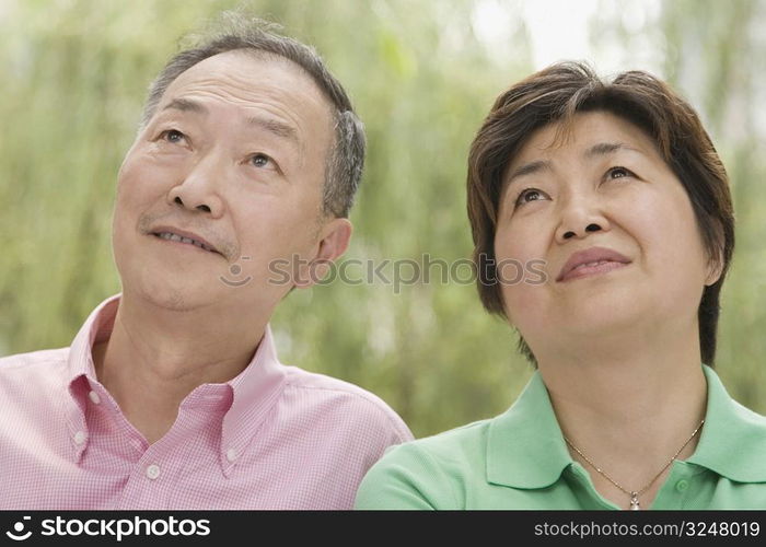 Close-up of a senior man and a mature woman looking up