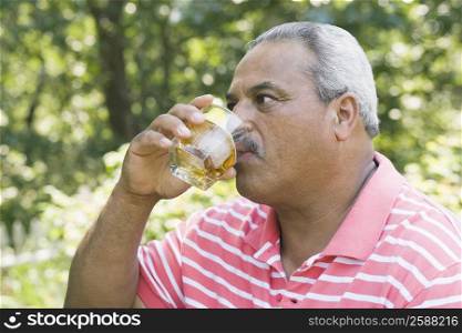 Close-up of a senior man drinking whiskey