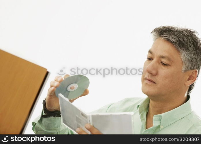 Close-up of a senior man holding a CD and a CD Case