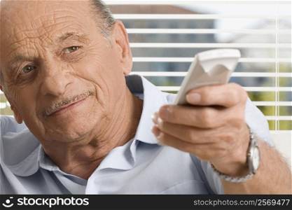 Close-up of a senior man operating a remote control
