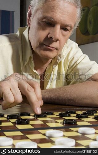 Close-up of a senior man playing checkers