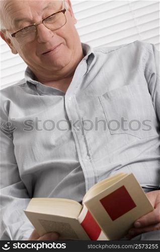 Close-up of a senior man reading a book