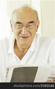 Close-up of a senior man reading a newspaper
