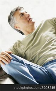Close-up of a senior man reclining on a couch and thinking