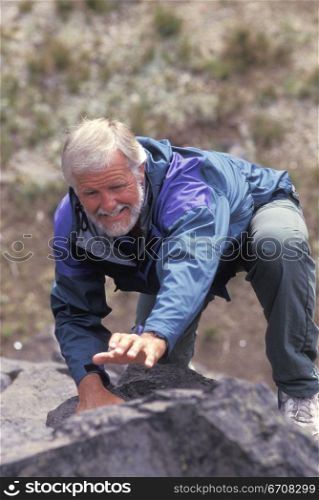 Close-up of a senior man rock climbing