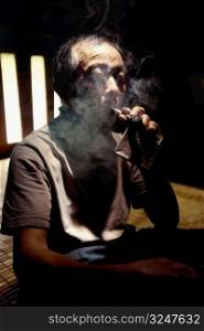Close-up of a senior man smoking a cigar, Jinkeng Terraced Field, Guangxi Province, China