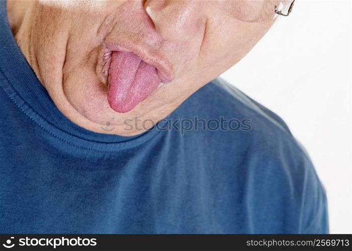 Close-up of a senior man sticking his tongue out