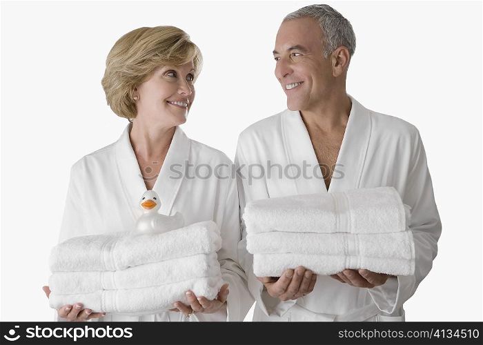 Close-up of a senior man with a mature woman standing together and holding folded towels