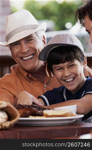 Close-up of a senior man with his grandson smiling in a restaurant