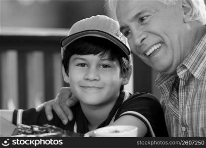 Close-up of a senior man with his grandson smiling in a restaurant