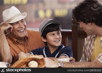 Close-up of a senior man with his son and grandson in a restaurant and smiling