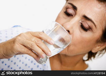 Close-up of a senior woman drinking water from a glass