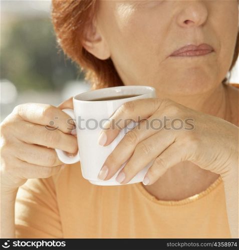 Close-up of a senior woman holding a coffee cup