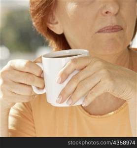 Close-up of a senior woman holding a coffee cup
