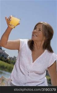 Close-up of a senior woman holding a glass of juice and smiling