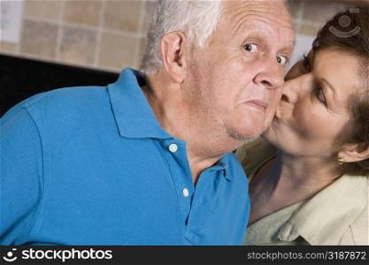 Close-up of a senior woman kissing a senior man