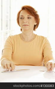 Close-up of a senior woman seated at the table looking away