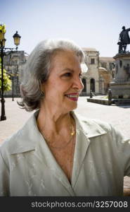 Close-up of a senior woman smiling with a statue in the background, Santo Domingo, Dominican Republic