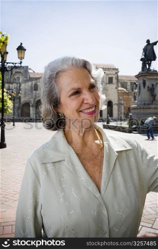 Close-up of a senior woman smiling with a statue in the background, Santo Domingo, Dominican Republic