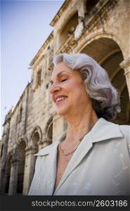 Close-up of a senior woman smiling with her eyes closed in front of a building, Santo Domingo, Dominican Republic