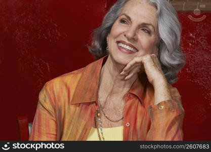 Close-up of a senior woman smiling with her hand on her chin