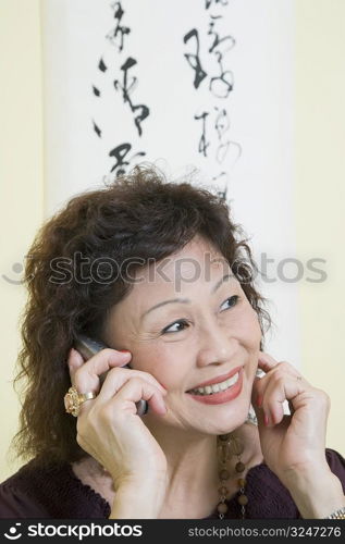 Close-up of a senior woman using a mobile phone and smiling