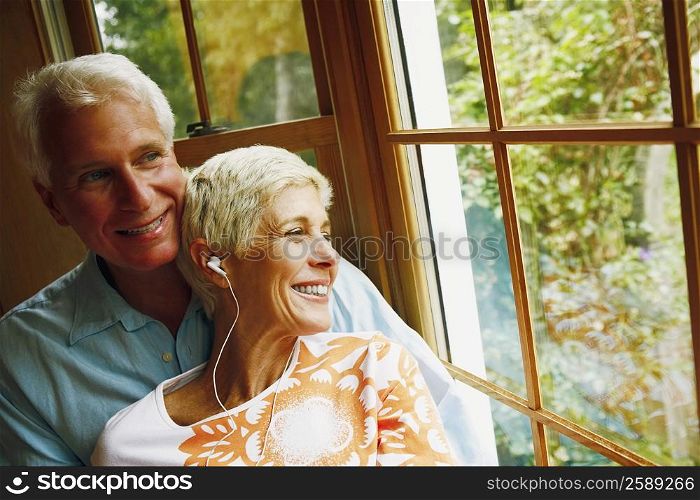 Close-up of a senior woman wearing headphones and smiling with a mature man