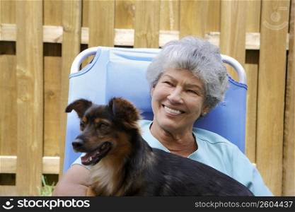 Close-up of a senior woman with a dog and smiling