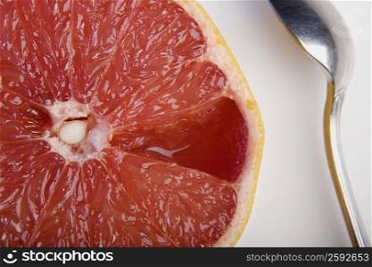 Close-up of a slice of orange and a spoon