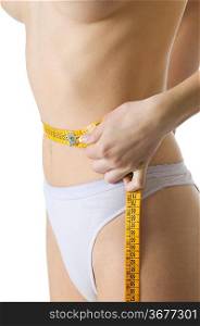 close up of a slim female body measuring her waist